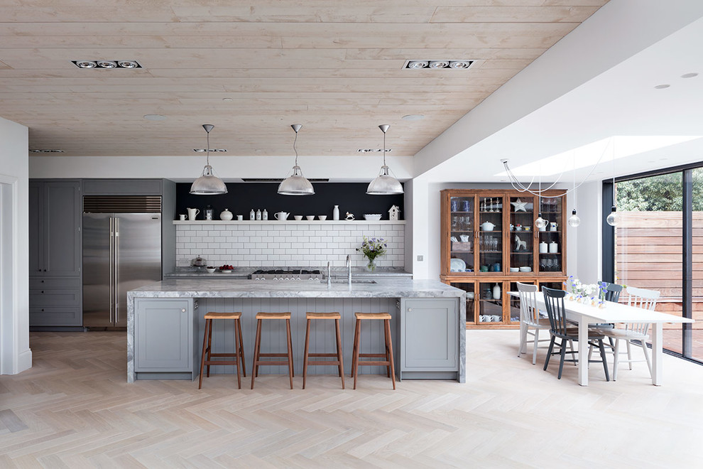 Esempio di una grande cucina design con lavello sottopiano, top in marmo, paraspruzzi bianco, paraspruzzi con piastrelle di cemento, parquet chiaro, pavimento beige e top grigio