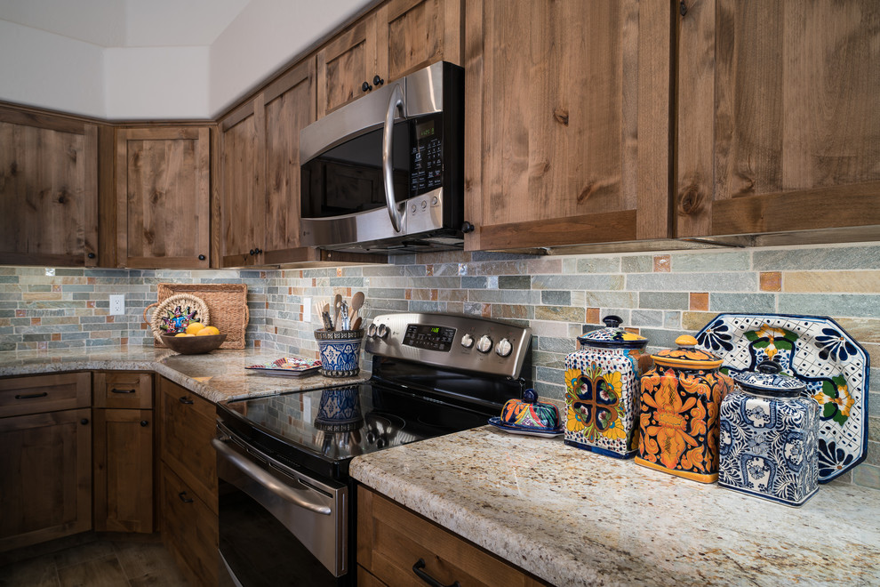 Mid-sized mountain style l-shaped porcelain tile and beige floor eat-in kitchen photo in Minneapolis with shaker cabinets, medium tone wood cabinets, granite countertops, green backsplash, stone tile backsplash, stainless steel appliances, an island and a farmhouse sink