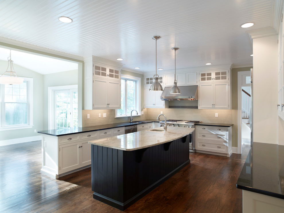 This is an example of an expansive traditional u-shaped kitchen/diner in Philadelphia with a submerged sink, white cabinets, laminate countertops, white splashback, stainless steel appliances, medium hardwood flooring and an island.