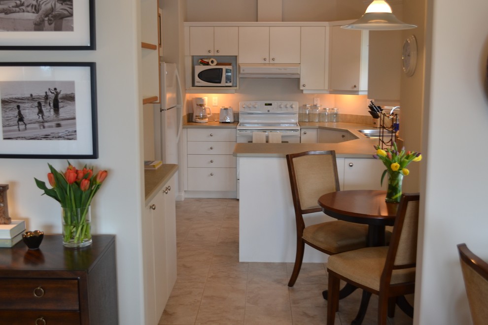 На фото: маленькая отдельная, п-образная кухня в восточном стиле с плоскими фасадами, белыми фасадами и столешницей из ламината для на участке и в саду с