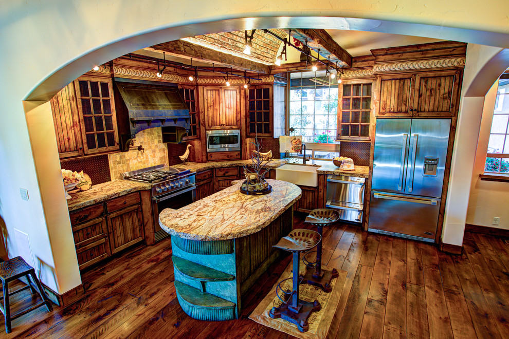 Foto på ett mellanstort rustikt kök, med en köksö, en rustik diskho, luckor med infälld panel, skåp i slitet trä, granitbänkskiva, stänkskydd med metallisk yta, stänkskydd i metallkakel, rostfria vitvaror och mörkt trägolv