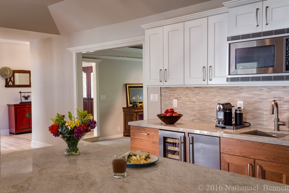 Example of a mid-sized transitional u-shaped light wood floor eat-in kitchen design in San Francisco with an undermount sink, shaker cabinets, white cabinets, beige backsplash, matchstick tile backsplash, stainless steel appliances and an island