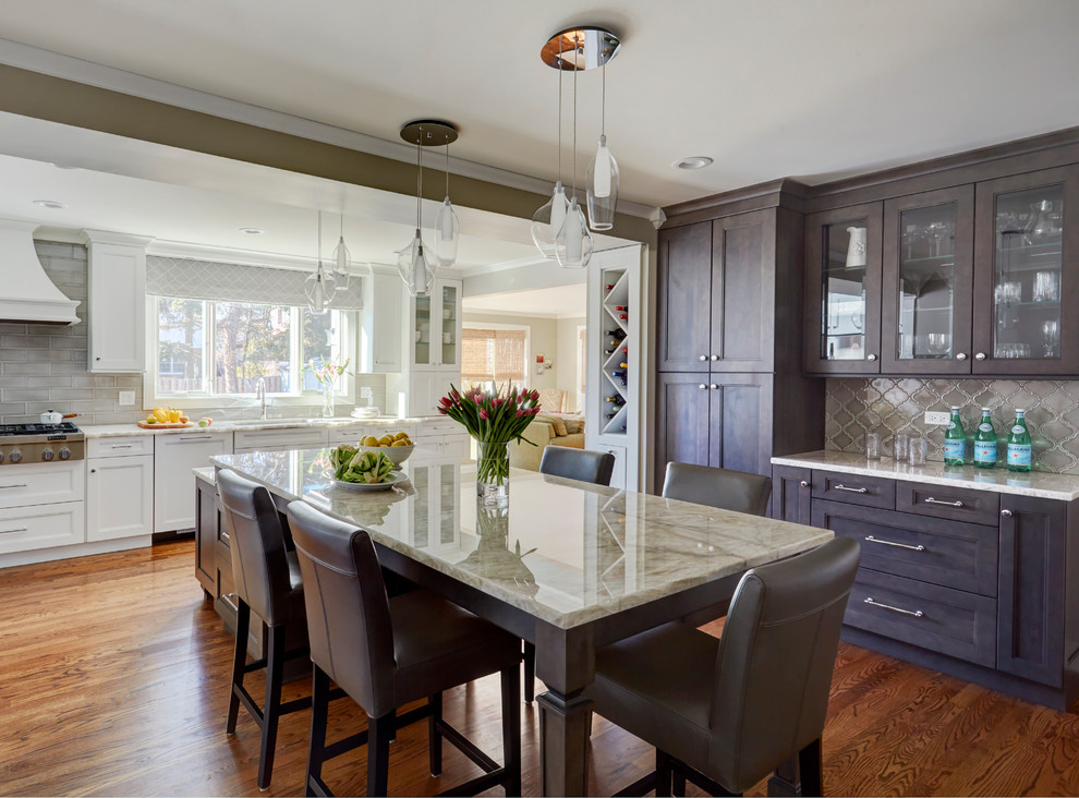 Example of a transitional medium tone wood floor and brown floor kitchen design in Chicago with an undermount sink, recessed-panel cabinets, dark wood cabinets, beige backsplash, an island and beige countertops