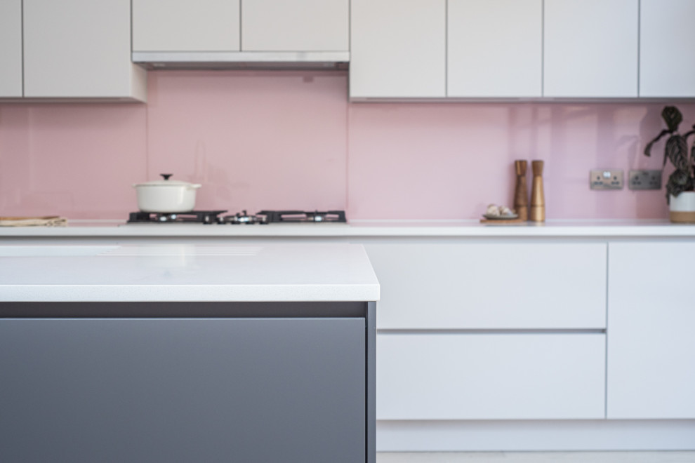 Immagine di una cucina contemporanea di medie dimensioni con lavello da incasso, ante lisce, ante grigie, top in quarzite, paraspruzzi rosa, paraspruzzi con lastra di vetro, parquet chiaro e top bianco