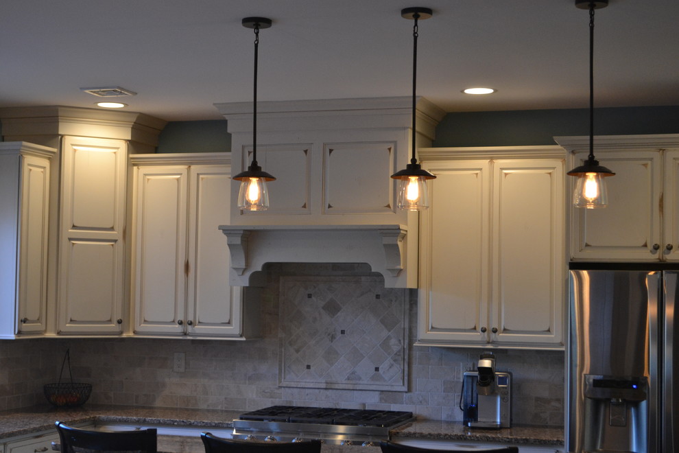 Exempel på ett stort klassiskt kök, med luckor med upphöjd panel, rostfria vitvaror, en köksö, en undermonterad diskho, vita skåp, granitbänkskiva, flerfärgad stänkskydd, stänkskydd i stenkakel och klinkergolv i keramik