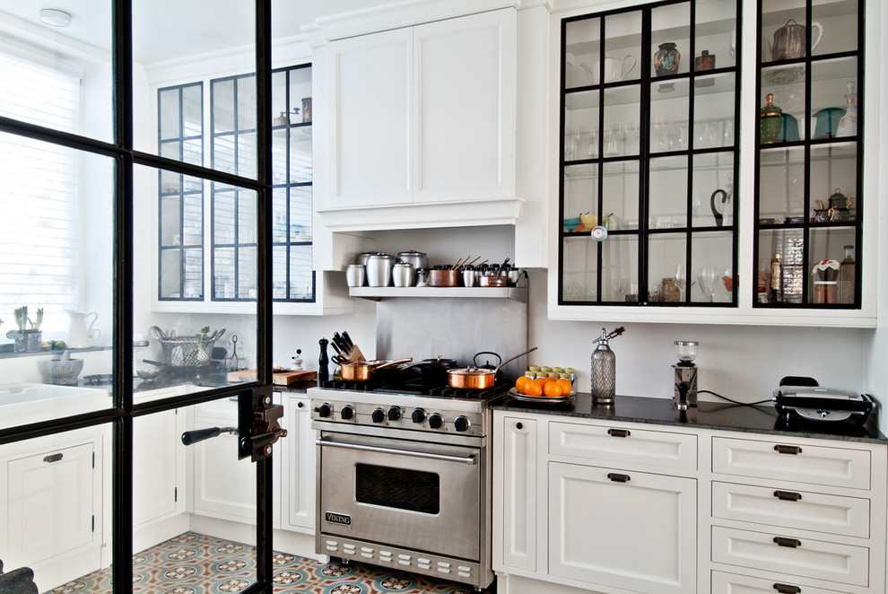 Geschlossene Moderne Küche in L-Form mit Landhausspüle, Glasfronten, weißen Schränken, Küchengeräten aus Edelstahl, Speckstein-Arbeitsplatte und Küchenrückwand in Weiß in Los Angeles