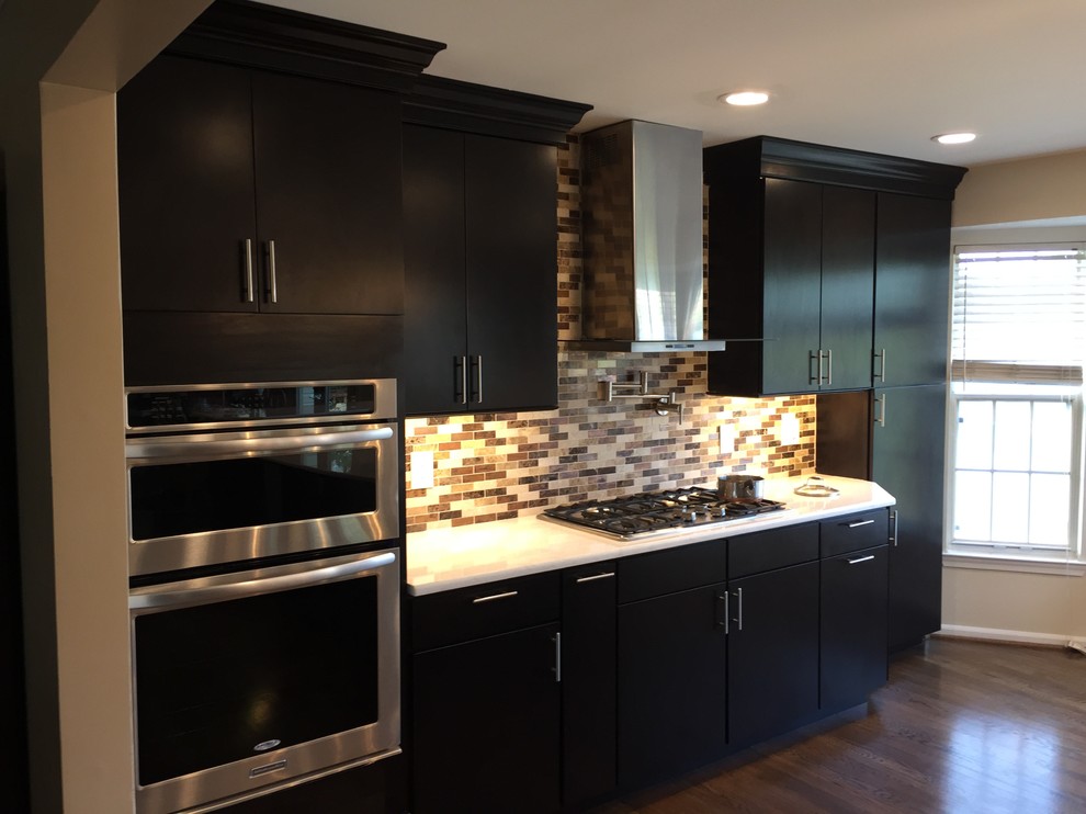 Eat-in kitchen - large contemporary galley dark wood floor eat-in kitchen idea in DC Metro with an undermount sink, flat-panel cabinets, black cabinets, quartzite countertops, beige backsplash, mosaic tile backsplash, stainless steel appliances and two islands