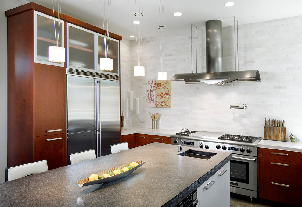 Inspiration for a mid-sized contemporary u-shaped kitchen remodel in Austin with an undermount sink, flat-panel cabinets, red cabinets, solid surface countertops, white backsplash, ceramic backsplash and stainless steel appliances