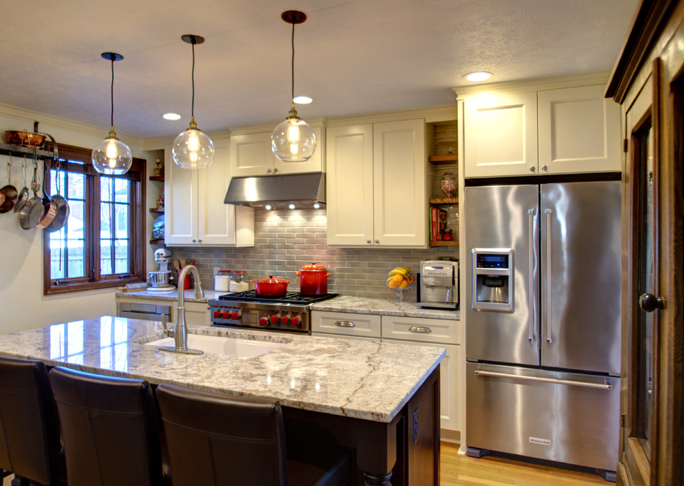 Immagine di una cucina chic chiusa e di medie dimensioni con lavello sottopiano, ante in stile shaker, ante beige, top in granito, paraspruzzi grigio, elettrodomestici in acciaio inossidabile e parquet chiaro