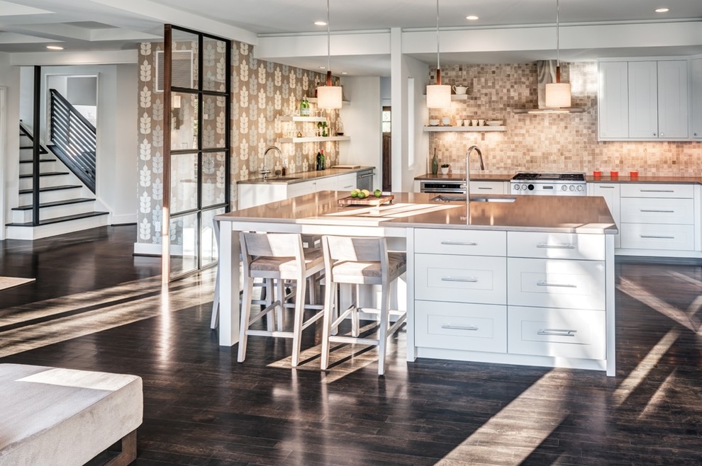 Exempel på ett kök, med en undermonterad diskho, luckor med infälld panel, vita skåp, bänkskiva i kvarts, brunt stänkskydd, stänkskydd i stenkakel, rostfria vitvaror, mörkt trägolv och en köksö