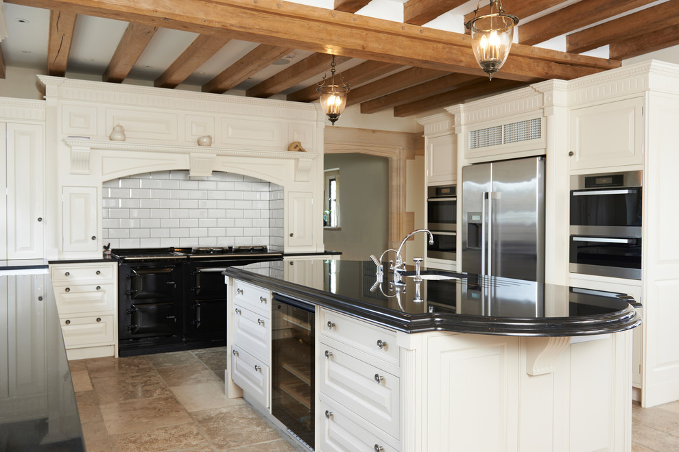 Design ideas for a large rural u-shaped open plan kitchen in New York with a belfast sink, beaded cabinets, white cabinets, granite worktops, white splashback, porcelain splashback, stainless steel appliances, travertine flooring and an island.