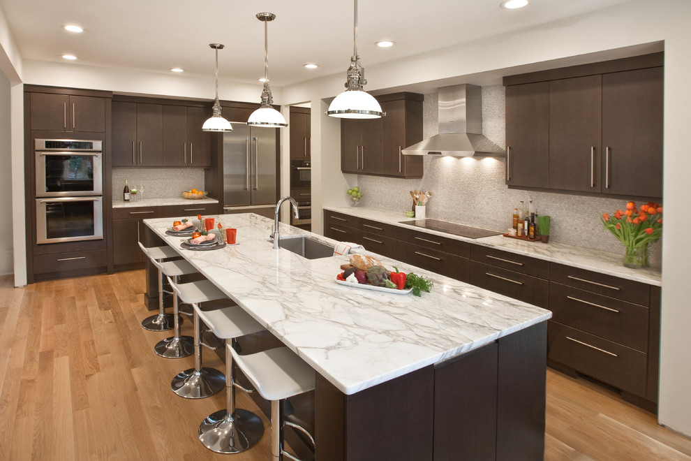 Example of a transitional medium tone wood floor eat-in kitchen design in Raleigh with a single-bowl sink, flat-panel cabinets, gray cabinets, marble countertops, mosaic tile backsplash, stainless steel appliances and an island