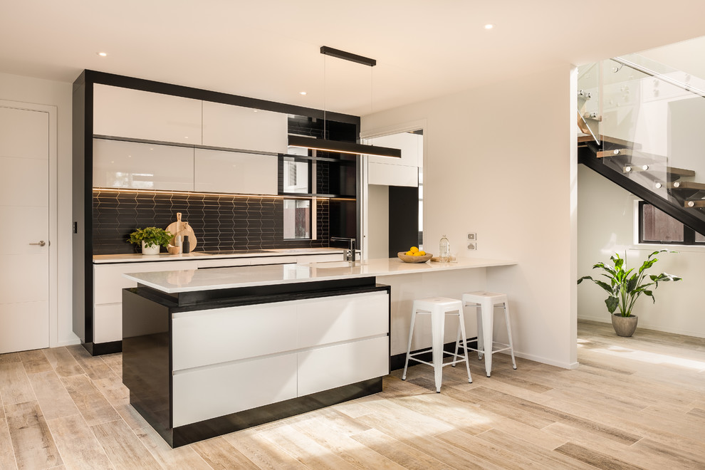 Zweizeilige Moderne Küche mit flächenbündigen Schrankfronten, Küchenrückwand in Schwarz, Kücheninsel, beigem Boden und weißer Arbeitsplatte in Christchurch