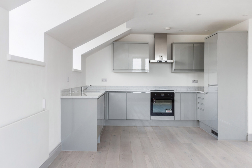 Modern u-shaped kitchen in Gloucestershire with laminate floors and no island.
