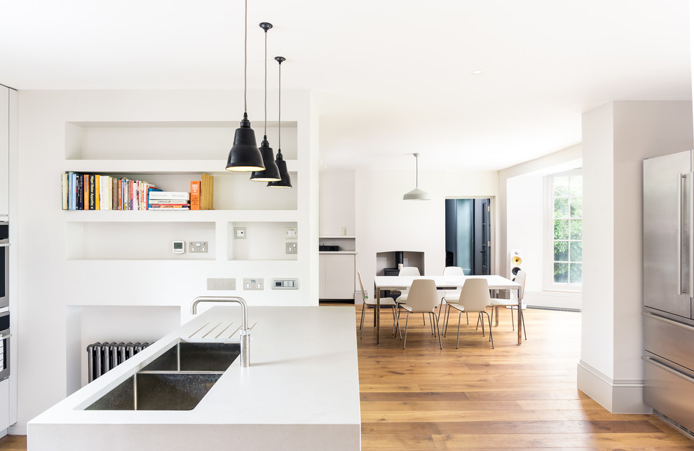 Example of a mid-sized minimalist u-shaped light wood floor and beige floor eat-in kitchen design in Sussex with flat-panel cabinets, gray cabinets, a peninsula, gray countertops, a double-bowl sink and granite countertops