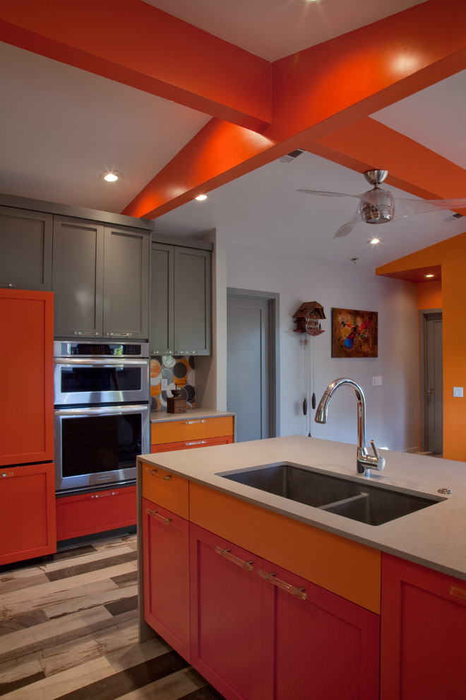 Esempio di una cucina minimalista di medie dimensioni con lavello sottopiano, ante in stile shaker, ante arancioni, top in quarzo composito, paraspruzzi arancione, paraspruzzi con piastrelle in ceramica, elettrodomestici in acciaio inossidabile, pavimento in gres porcellanato e penisola