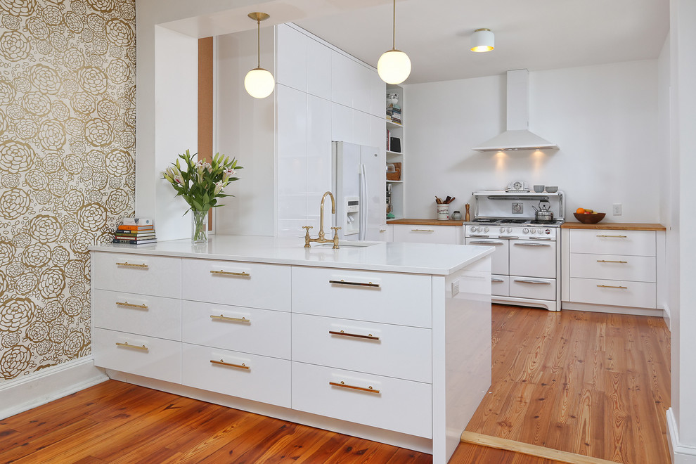 Photo of a medium sized contemporary u-shaped enclosed kitchen in Philadelphia with a submerged sink, flat-panel cabinets, white cabinets, engineered stone countertops, white appliances, medium hardwood flooring and a breakfast bar.