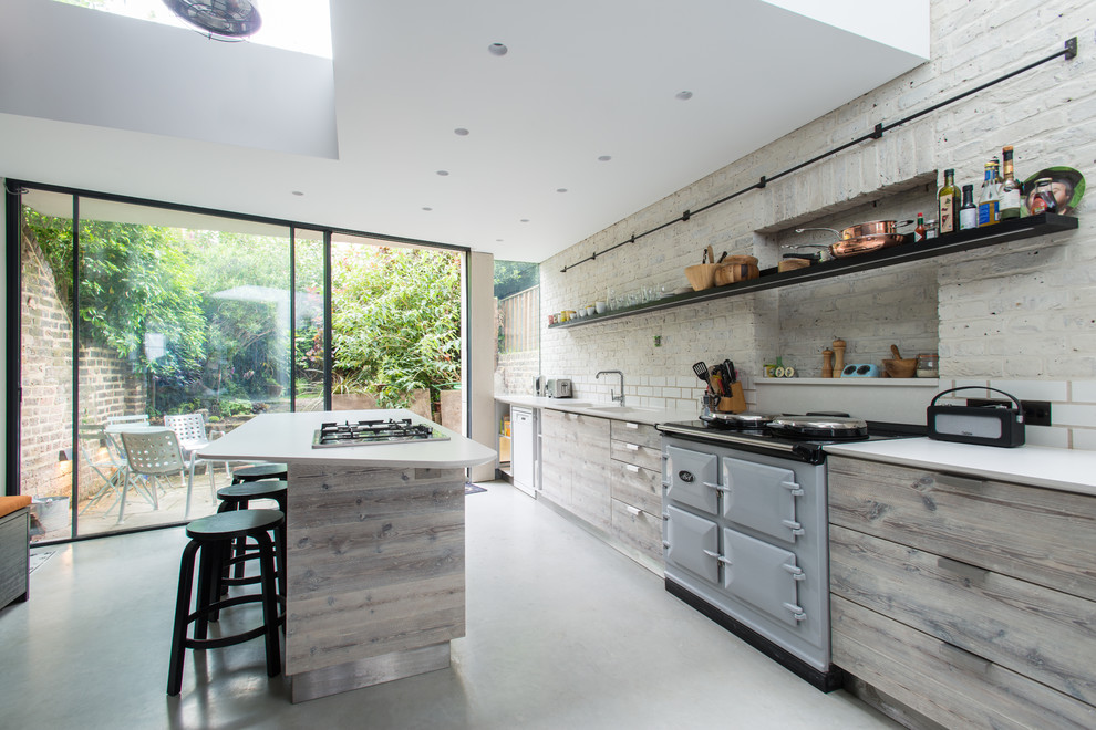 Foto på ett mellanstort minimalistiskt linjärt kök och matrum, med släta luckor, grå skåp, bänkskiva i kvartsit, vitt stänkskydd, stänkskydd i keramik, betonggolv, en halv köksö och grått golv