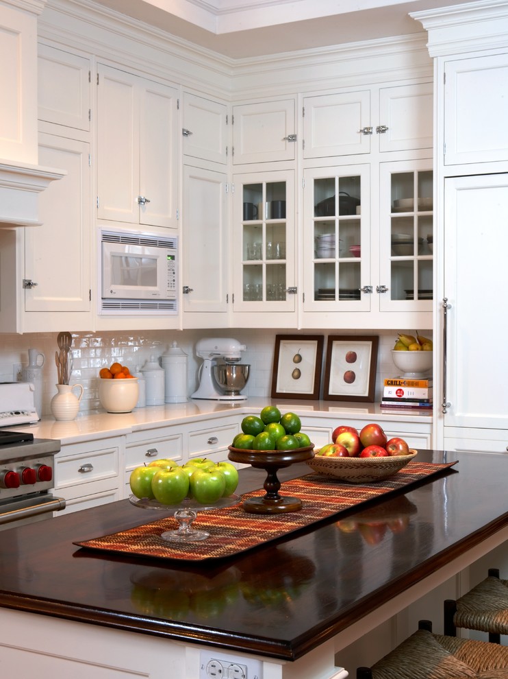 На фото: кухня в классическом стиле с фасадами с утопленной филенкой, белыми фасадами, белым фартуком и фартуком из плитки кабанчик с