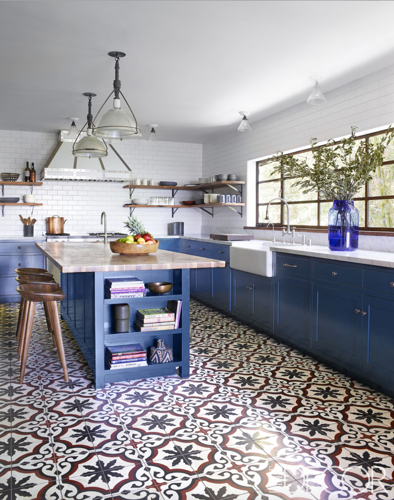 Klassische Küche in L-Form mit blauen Schränken, Küchenrückwand in Weiß, Kücheninsel, Betonboden, Landhausspüle, Schrankfronten im Shaker-Stil und Rückwand aus Metrofliesen in Los Angeles