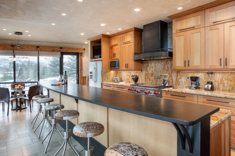 Cette image montre une cuisine américaine parallèle traditionnelle en bois brun de taille moyenne avec îlot, un plan de travail beige, un placard à porte shaker, une crédence multicolore et un sol gris.