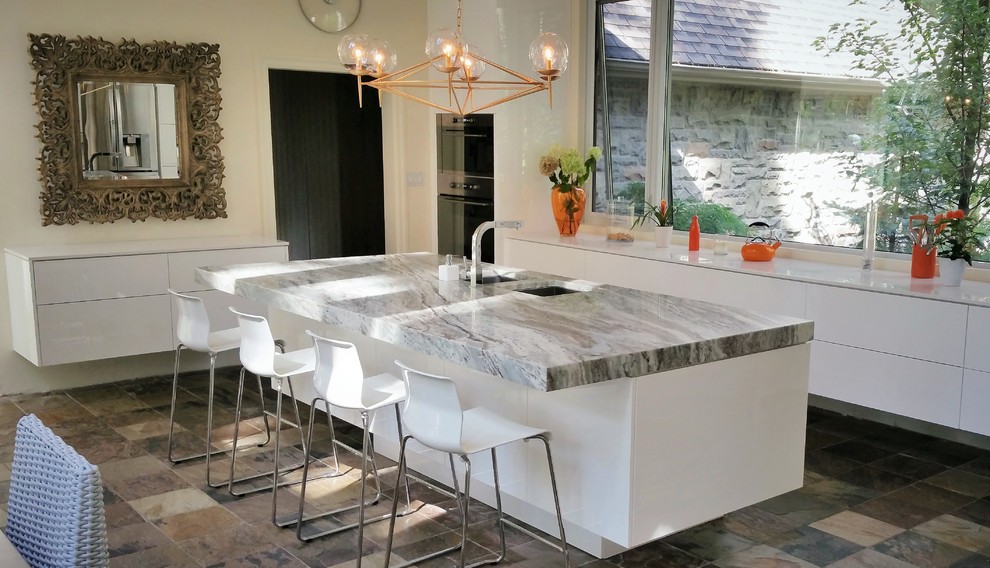 Idéer för ett mellanstort modernt kök, med släta luckor, vita skåp, en köksö, en undermonterad diskho, rostfria vitvaror, skiffergolv och marmorbänkskiva