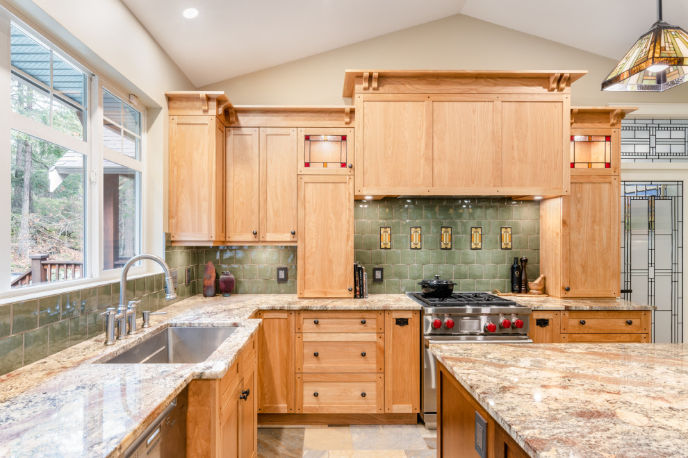 Idée de décoration pour une cuisine ouverte craftsman en L et bois brun de taille moyenne avec un évier encastré, un placard à porte shaker, un plan de travail en granite, une crédence verte, une crédence en céramique, un électroménager en acier inoxydable, un sol en carrelage de porcelaine, îlot, un sol multicolore et un plan de travail beige.