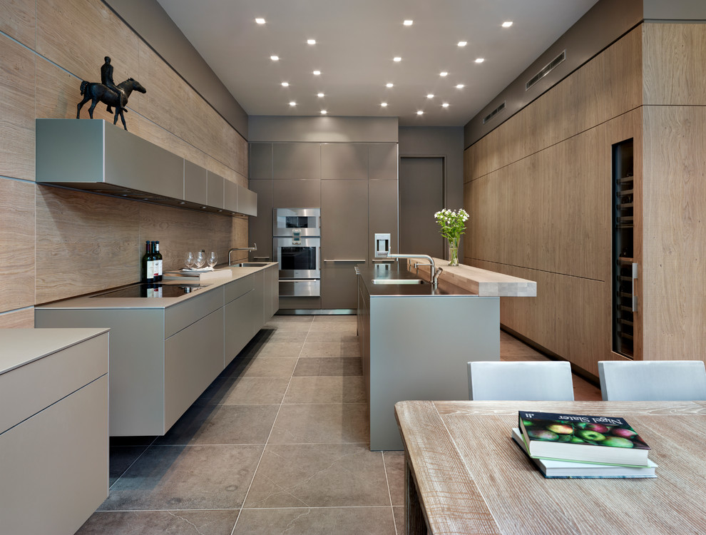 Moderne Wohnküche in U-Form mit integriertem Waschbecken, flächenbündigen Schrankfronten, grauen Schränken, Edelstahl-Arbeitsplatte, Küchengeräten aus Edelstahl und Kücheninsel in Cheshire