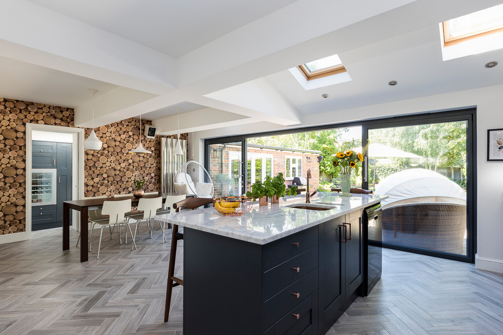 Mittelgroße Moderne Wohnküche mit Schrankfronten mit vertiefter Füllung, blauen Schränken, Marmor-Arbeitsplatte, Halbinsel und grauem Boden in London