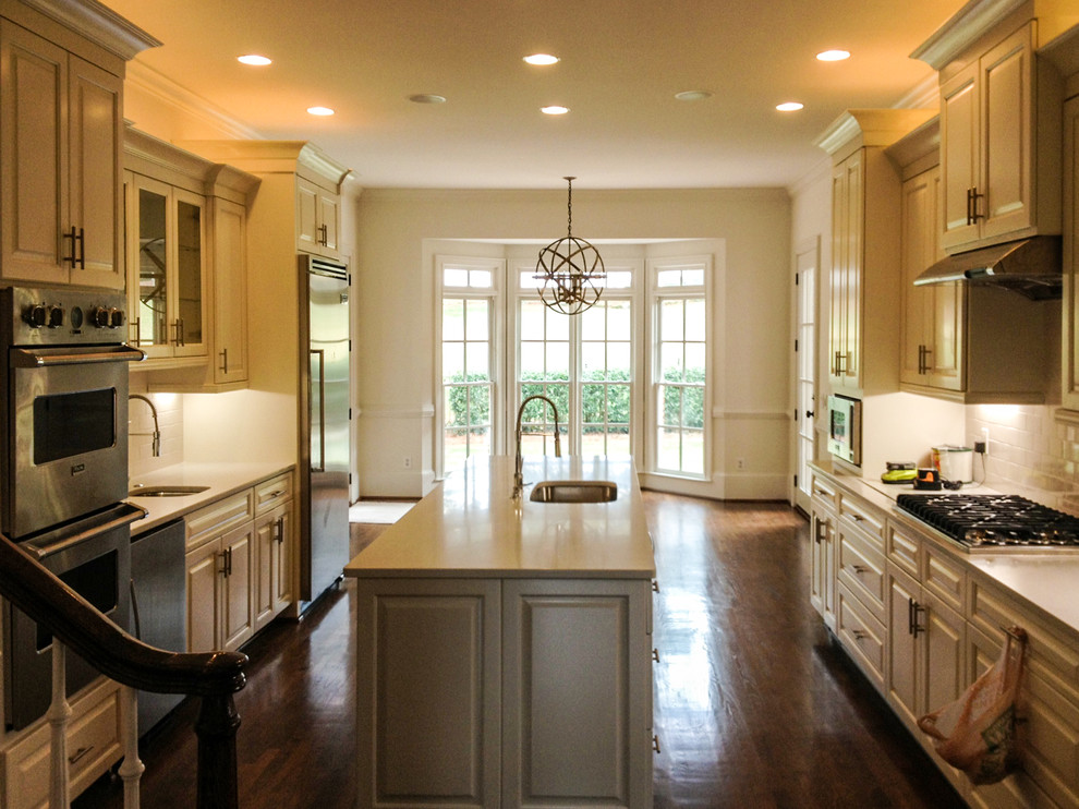 Eat-in kitchen - large transitional u-shaped dark wood floor and brown floor eat-in kitchen idea in Atlanta with a double-bowl sink, raised-panel cabinets, white cabinets, quartz countertops, white backsplash, subway tile backsplash, stainless steel appliances and an island