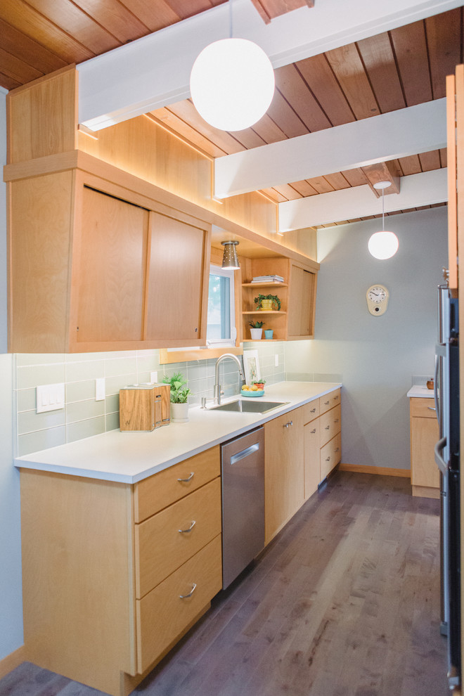 Design ideas for a small midcentury kitchen in Grand Rapids with flat-panel cabinets, light wood cabinets, laminate countertops, grey splashback, glass tiled splashback, stainless steel appliances, medium hardwood flooring, no island, a single-bowl sink and white worktops.