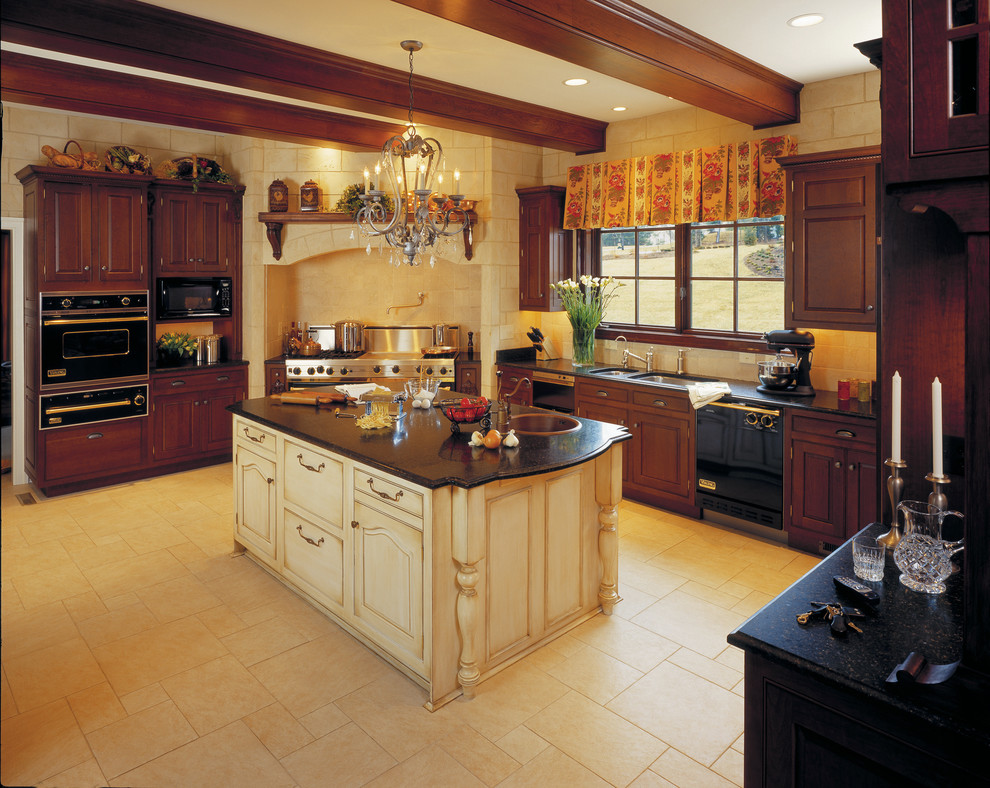 Cette image montre une cuisine américaine traditionnelle en U et bois foncé avec un évier posé, un placard à porte vitrée, un plan de travail en granite et un électroménager noir.