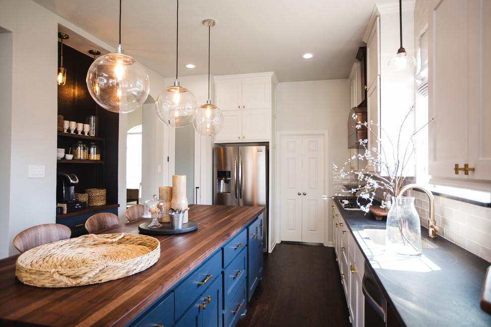 Photo of a large classic single-wall kitchen/diner in Dallas with a built-in sink, shaker cabinets, white cabinets, wood worktops, grey splashback, ceramic splashback, stainless steel appliances, dark hardwood flooring and an island.