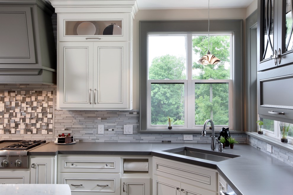 Inspiration for a large transitional l-shaped medium tone wood floor eat-in kitchen remodel in Grand Rapids with an undermount sink, concrete countertops, gray backsplash, glass tile backsplash, stainless steel appliances and an island