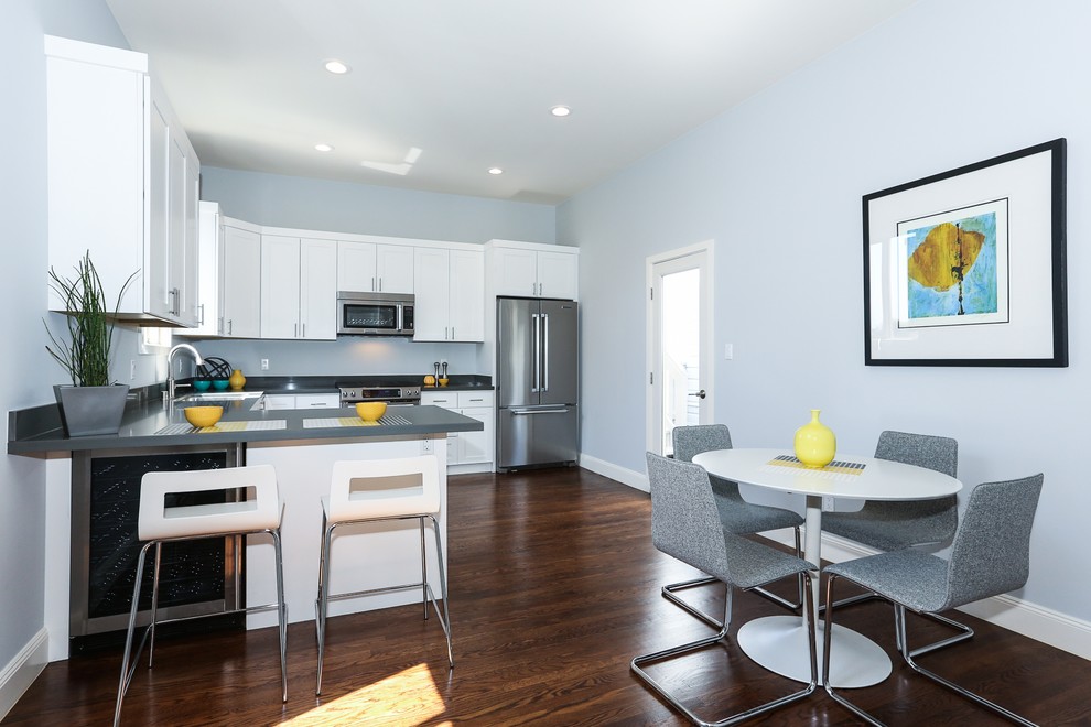 Exempel på ett mellanstort modernt grå grått kök, med skåp i shakerstil, vita skåp, bänkskiva i kvarts, rostfria vitvaror, mörkt trägolv, en halv köksö och brunt golv