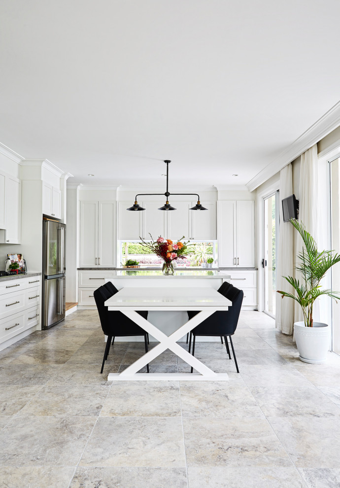 Bild på ett stort vintage vit vitt kök, med en dubbel diskho, luckor med infälld panel, vita skåp, bänkskiva i kvarts, vitt stänkskydd, stänkskydd i keramik, rostfria vitvaror, travertin golv, en köksö och grått golv