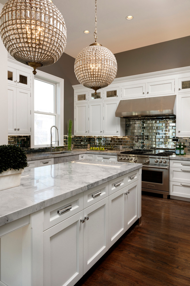 Example of a mid-sized eclectic u-shaped dark wood floor eat-in kitchen design in Baltimore with a farmhouse sink, recessed-panel cabinets, white cabinets, quartzite countertops, mirror backsplash, paneled appliances, an island and metallic backsplash