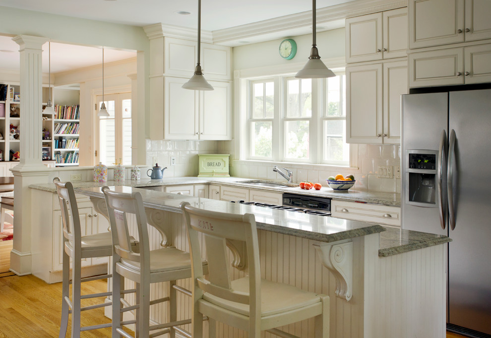 Idéer för att renovera ett mellanstort vintage kök, med en undermonterad diskho, luckor med upphöjd panel, vita skåp, vitt stänkskydd, rostfria vitvaror, marmorbänkskiva, stänkskydd i keramik, mellanmörkt trägolv och en köksö