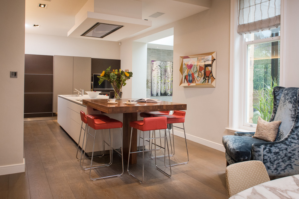 Offene Moderne Küche mit Unterbauwaschbecken, flächenbündigen Schrankfronten, braunem Holzboden und zwei Kücheninseln in Sonstige