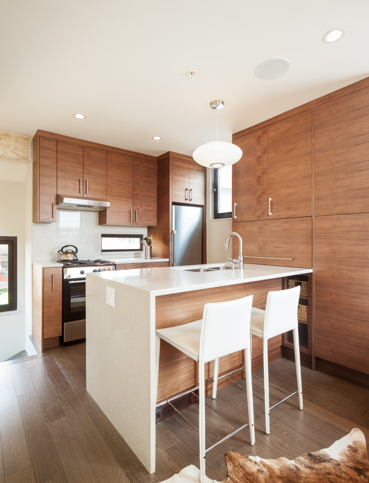Eat-in kitchen - small contemporary galley medium tone wood floor and gray floor eat-in kitchen idea in Vancouver with flat-panel cabinets, medium tone wood cabinets, a peninsula, quartz countertops, white backsplash, stainless steel appliances and a double-bowl sink