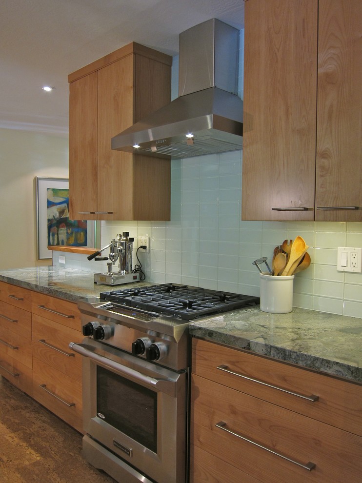 Moderne Küche in U-Form mit hellen Holzschränken, Granit-Arbeitsplatte, Rückwand aus Glasfliesen, Küchengeräten aus Edelstahl, Korkboden, flächenbündigen Schrankfronten, Küchenrückwand in Grau und grüner Arbeitsplatte in San Francisco