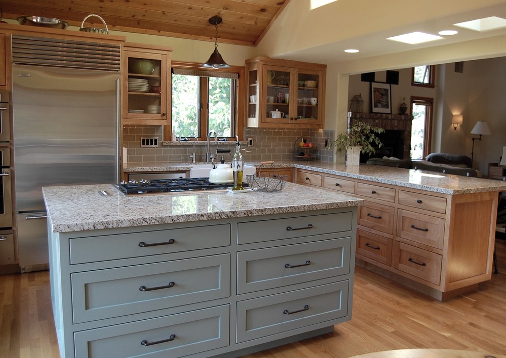 Mid-sized country l-shaped light wood floor eat-in kitchen photo in Los Angeles with a farmhouse sink, shaker cabinets, light wood cabinets, granite countertops, gray backsplash, subway tile backsplash, stainless steel appliances and an island
