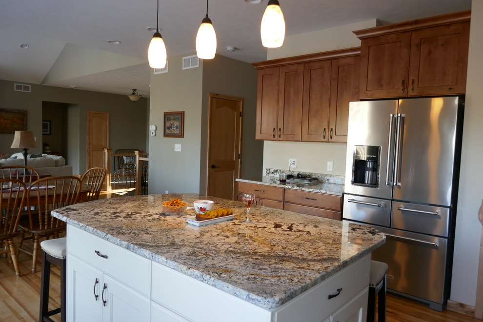 Foto på ett mellanstort vintage kök och matrum, med skåp i mellenmörkt trä, granitbänkskiva, rostfria vitvaror, mellanmörkt trägolv, en köksö, beiget golv och skåp i shakerstil