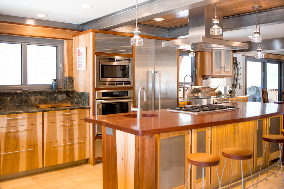 Exempel på ett mellanstort rustikt kök, med en undermonterad diskho, släta luckor, skåp i ljust trä, granitbänkskiva, svart stänkskydd, stänkskydd i sten, rostfria vitvaror, kalkstensgolv och en halv köksö