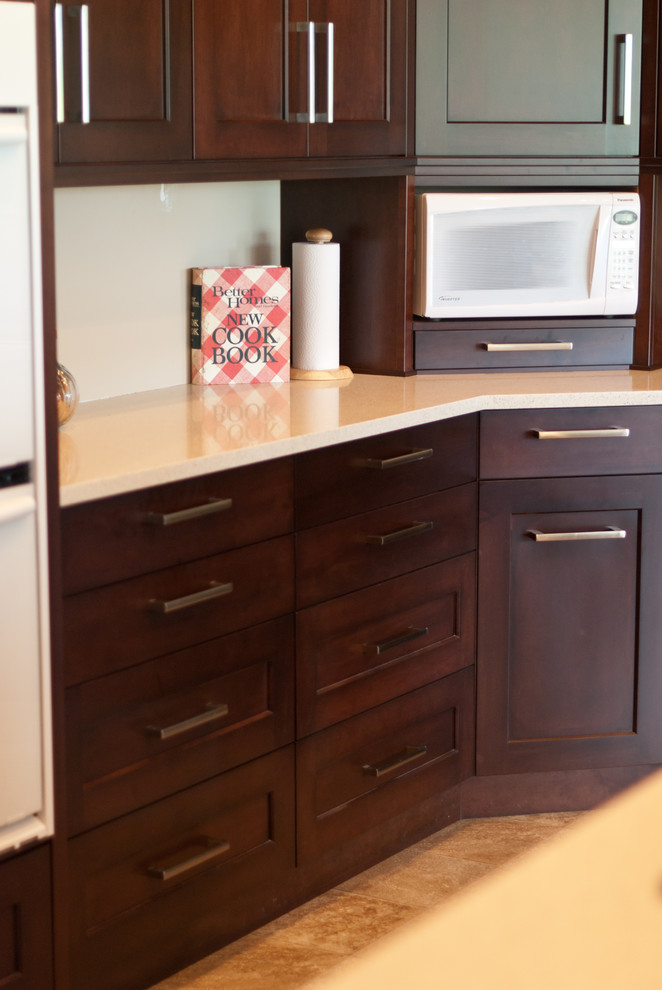 Exemple d'une cuisine américaine tendance en L et bois brun avec un placard à porte shaker, un plan de travail en quartz modifié et un électroménager blanc.