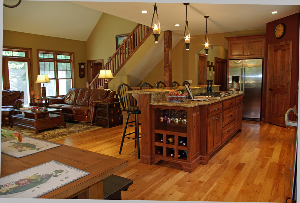 Inspiration for a mid-sized timeless single-wall medium tone wood floor open concept kitchen remodel in Milwaukee with raised-panel cabinets, medium tone wood cabinets, stainless steel appliances, an island and granite countertops