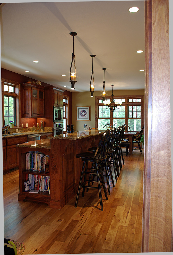 Inspiration för ett mellanstort vintage linjärt kök med öppen planlösning, med luckor med upphöjd panel, skåp i mellenmörkt trä, rostfria vitvaror, mellanmörkt trägolv, en köksö och granitbänkskiva