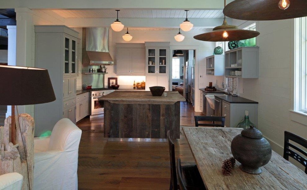 Eat-in kitchen - mid-sized rustic u-shaped medium tone wood floor and brown floor eat-in kitchen idea in Charleston with a farmhouse sink, open cabinets, gray cabinets, solid surface countertops, white backsplash, stainless steel appliances and an island