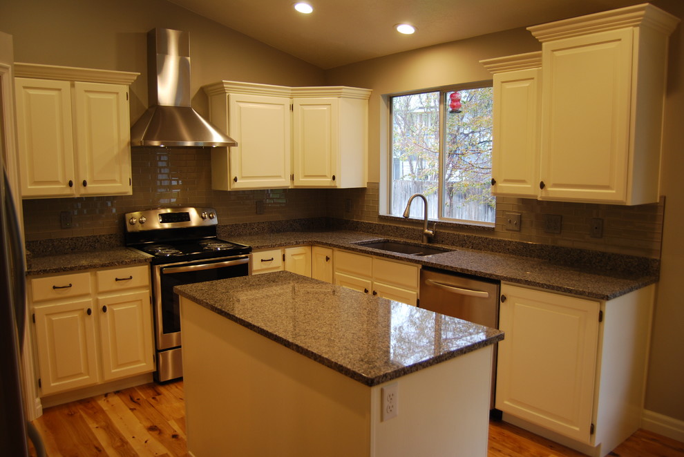 Example of a small transitional u-shaped light wood floor and brown floor eat-in kitchen design in Other with a double-bowl sink, raised-panel cabinets, white cabinets, gray backsplash, subway tile backsplash, stainless steel appliances, an island and granite countertops