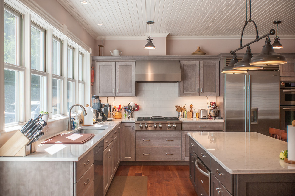Große Klassische Küche in L-Form mit Unterbauwaschbecken, Quarzit-Arbeitsplatte, Küchenrückwand in Weiß, Küchengeräten aus Edelstahl, braunem Holzboden, Kücheninsel, Schrankfronten im Shaker-Stil, hellen Holzschränken, Rückwand aus Metrofliesen und braunem Boden in Boston